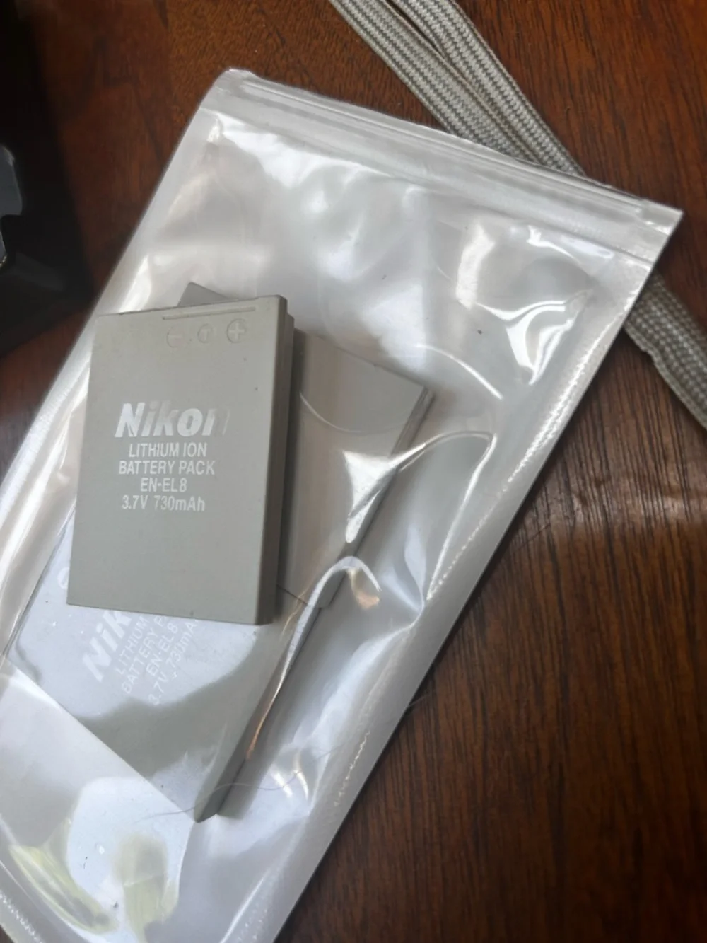 Three NEW lithium ion batteries; used charger for Nikon Coolpix camera.